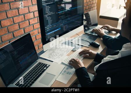 Two partnerships developing programming and coding technologies working on laptop and analyzing together. Stock Photo