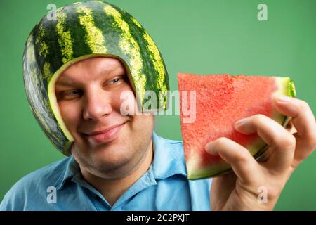 Bizarre man in a helmet from a watermelon preparing to eat Stock Photo