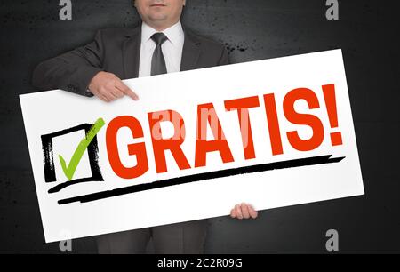 Gratis (in german free of charge) poster is held by businessman. Stock Photo