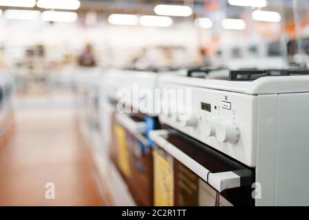 Row of new gas stoves in electronics store, nobody. Electric home appliances sale in supermarket Stock Photo