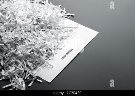Big heap of white shredded papers on list with agreement Stock Photo