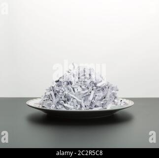 Plate of heap of white shredded papers isolated on white Stock Photo