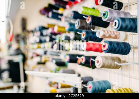 Colorful threads on spools closeup, sewing material, yarn on bobbins macro view Stock Photo