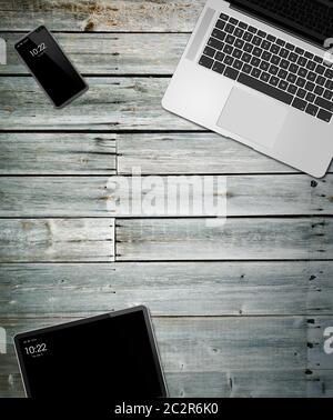 Laptop, tablet and phone set mockup on a wooden desk background. 3D render Stock Photo