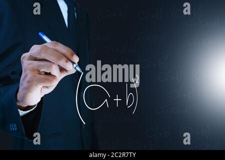 Man writing the mathematical equations Stock Photo