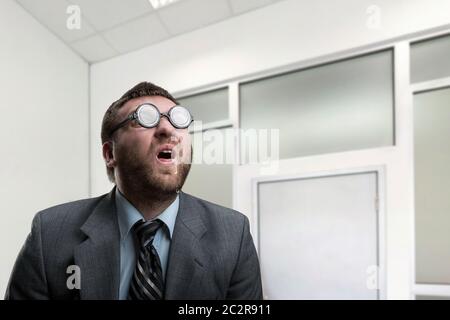 Surprised nerd businessman in glasses at office Stock Photo