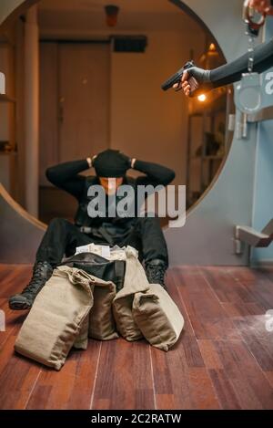 Bank robbery, two robbers in black uniform could not divide the money. Criminal profession, theft concept Stock Photo