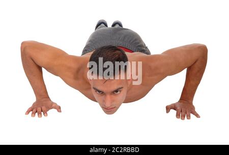 A young east Indian man doing his push aps on the floor in the studio isolated for white background Stock Photo