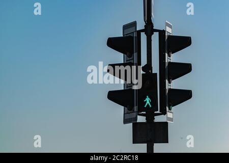 Street traffic light on which the permission signal for pedestrians is lit. Stock Photo