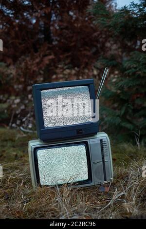 White noise and nothing on two analogue TV sets in outdoor environment Stock Photo