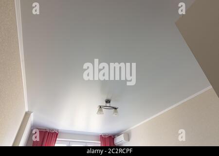 Stretched white matte ceiling in the room close-up Stock Photo