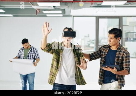One of architects wearing VR googles using Augmented Reality technology in his work, horizontal shot Stock Photo