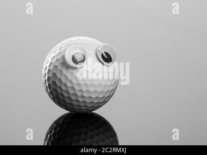 Golf ball with eyes on grey background Stock Photo