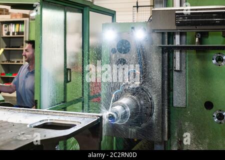 Worker operating industrial milling machine in factory Stock Photo