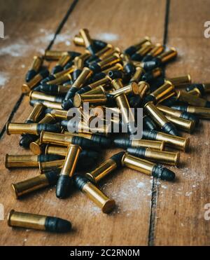 .22 ammunition in pile on a board surrounded by powder Stock Photo