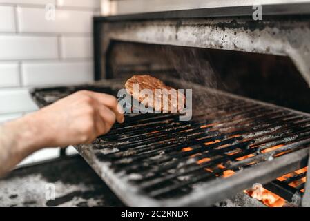 Cook hands prepares smoky meat on grill oven burger cooking. Hamburger preparation process fast food bbq Stock Photo Alamy