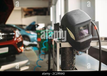 Welding helmet in car service , nobody. Professional auto-service tools and equipment, auto body works Stock Photo