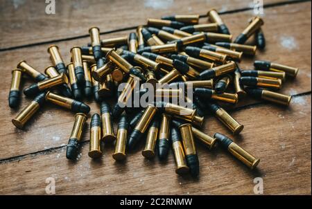 .22 ammunition in pile on a board surrounded by powder Stock Photo