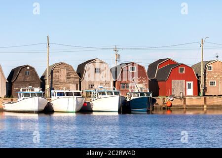 A line of Oyster barns and fishing boats at Malpeque Harbour on the north shore of Prince Edward Island (PEI) , Canada Stock Photo