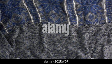 gray knitted fabric with a blue pattern, full frame, detail of a woolen scarf Stock Photo