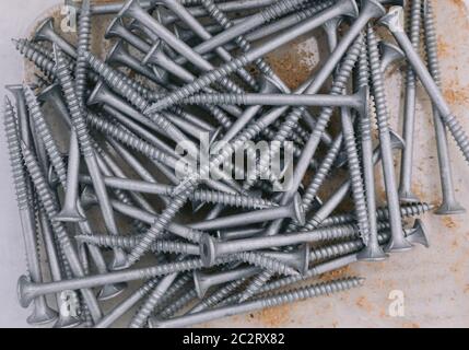 Bugle Batten Screws in box with saw dust scattered through box Stock Photo