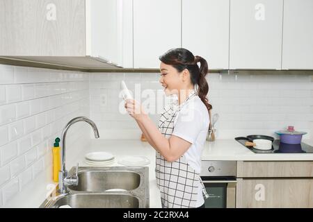 Look how clean. Pretty woman standing in kitchen and showing results of her work Stock Photo