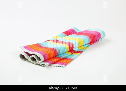 Colorful striped ribbed woven cotton place mat - folded Stock Photo