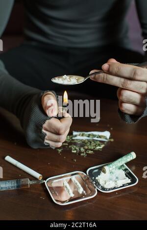 Addict in depression preparing dose of heroin. Abuse of drugs leads to a depression Stock Photo