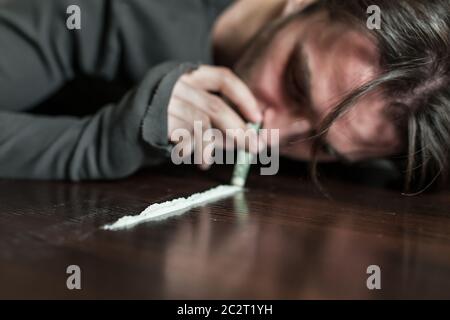 Addict in depression smells cocaine trace. Abuse of drugs leads to a depression. Stock Photo