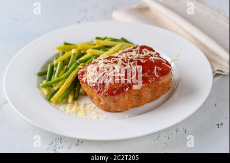 Meatloaf topped with tomato sauce with green beans Stock Photo