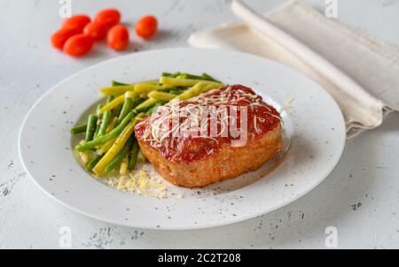 Meatloaf topped with tomato sauce with green beans Stock Photo