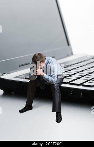 Office employee sitting on laptop thinks Stock Photo
