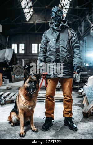 Stalker soldier in gas mask and dog in radioactive zone, friends in post apocalyptic world. Post-apocalypse lifestyle on ruins, doomsday, judgment day Stock Photo