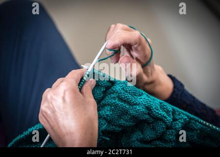 A womans hands knitting with wool. Stock Photo