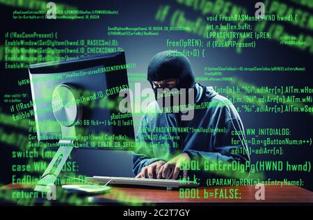 Hacker in mask stealing information in the office Stock Photo
