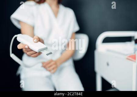 Female beautician hands prepares equipment to procedure, cosmetology cabinet. Doctor in white uniform in spa salon, beauty medicine Stock Photo