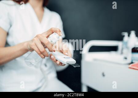 Female beautician hands prepares equipment to procedure, cosmetology cabinet. Doctor in white uniform in spa salon, beauty medicine Stock Photo