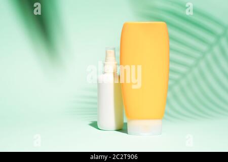 White and orange spray containers without label on turquoise background, place for text Stock Photo