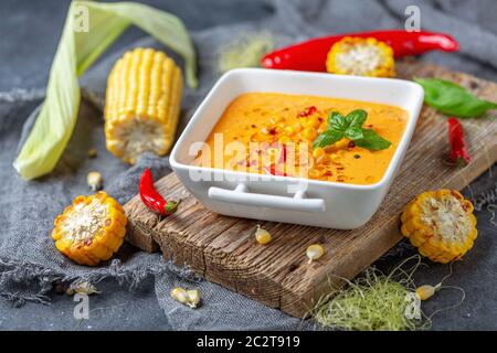 Delicious creamy corn soup with chili in a bowl. Stock Photo