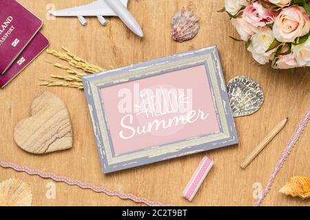 Mockup Photo Frame Travel Summer Holiday Background Concept. Flat lay top view mock up picture frame, passport, sea shells, flower, plane model. Stock Photo