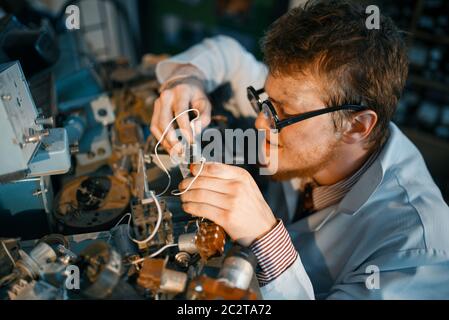 Crazy scientist prototyping electrical device in laboratory. Electrical ...