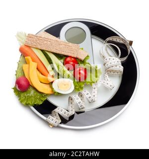 Still life with healthy food, scales and measuring tape on white background. Healthy nutrition. Healthy lifestyle concept. Slimming, diet, and control Stock Photo