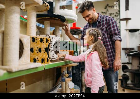 Father and little daughter buying supplies for cat in petshop. Family chooses accessories for dog in pet shop Stock Photo