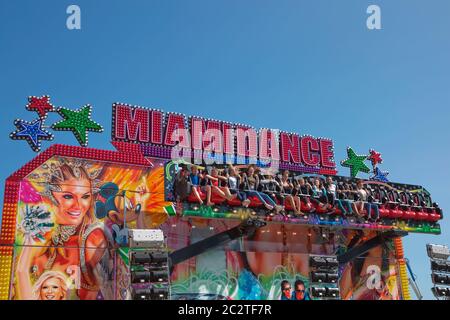 Carousel in amusement park in Weymouth in UK. People enjoying adrenaline and fun. Stock Photo