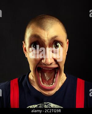 Portrait of very surprised screaming man with giant eyes and open mouth Stock Photo