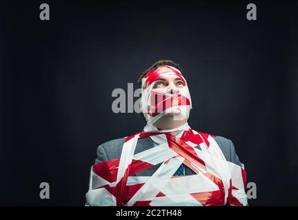 Victum man with stripped  red and white duct tape over body Stock Photo