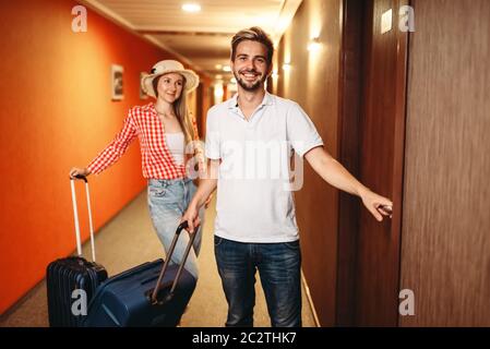 Happy couple with suitcases checking into the hotel. Travelling or tourism concept Stock Photo
