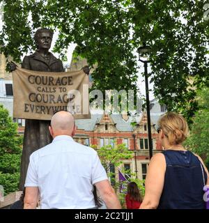 People look at bronze statue of Millicent Garrett Fawcett, women's rights activist and suffragist, Parliament Square, London Stock Photo