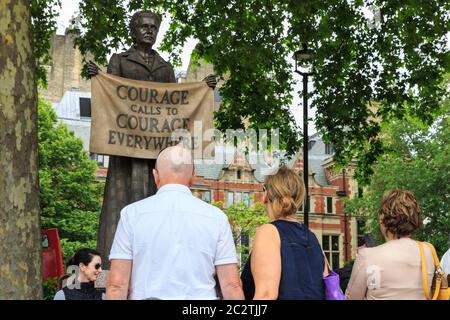 People look at bronze statue of Millicent Garrett Fawcett, women's rights activist and suffragist, Parliament Square, London Stock Photo