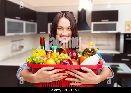 Young girl with a basket full of goods Stock Photo